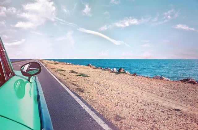 Groene auto langs de kust