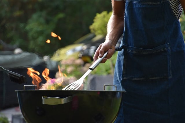 Man achter barbecue