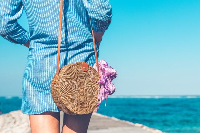 Vrouw op het strand in zomerse mode